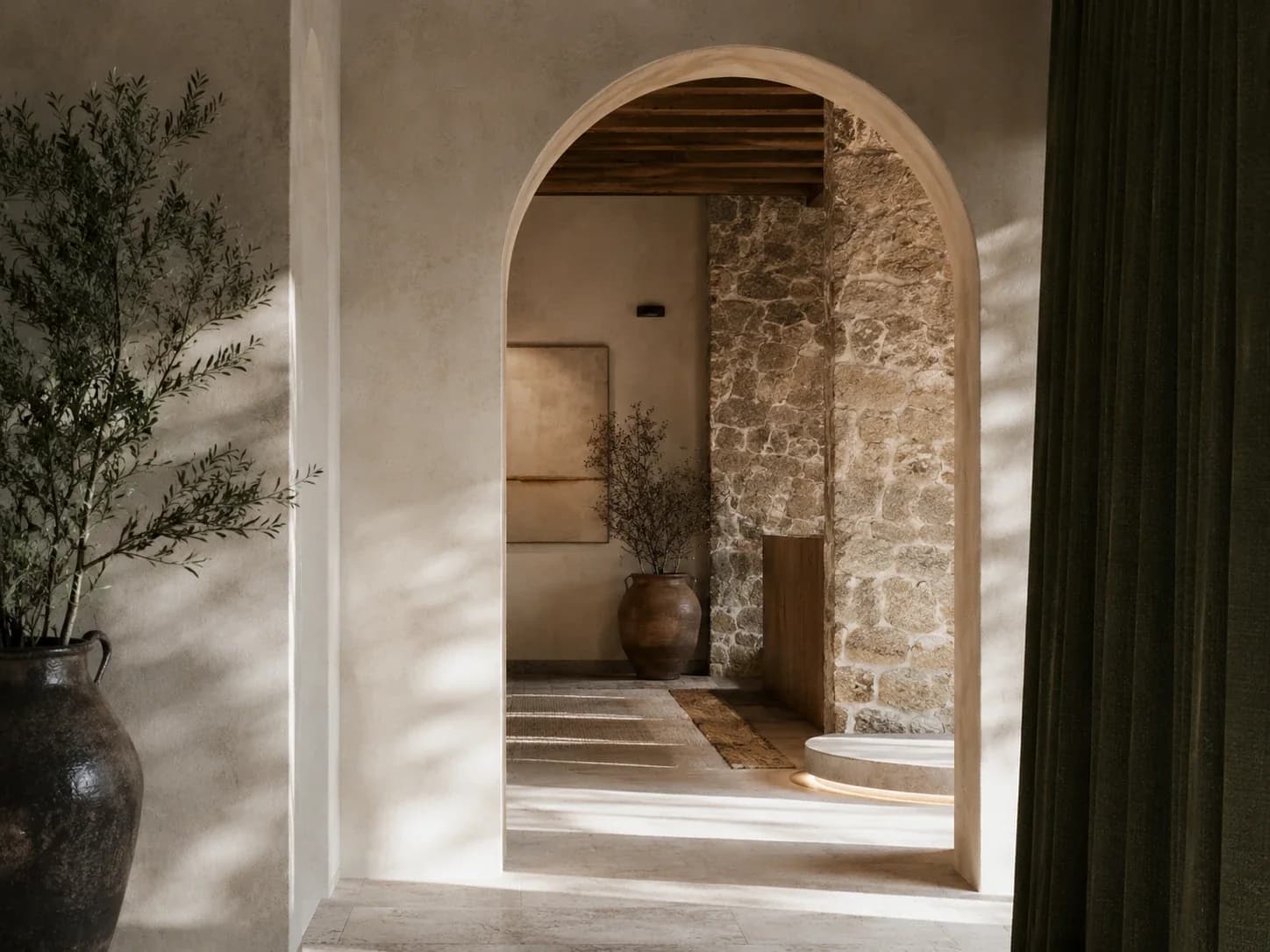 Warm plaster archway opening onto a stone-walled interior in low afternoon light.